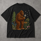 SF_COLOR=black; SF_ITEM=adult-t-shirt; SF_ROLE=main; Funny Bigfoot Blowing A Dandelion T-Shirt Retro Floral Sasquatch Outdoors Tee - Black Adult T-Shirt product image